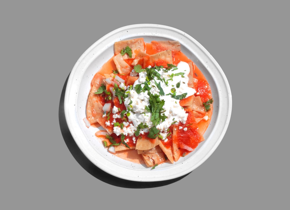 sliced carrots and green vegetable salad in white ceramic bowl