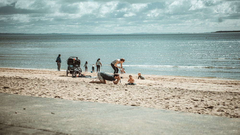 Personas sentadas en la orilla de la playa durante el día