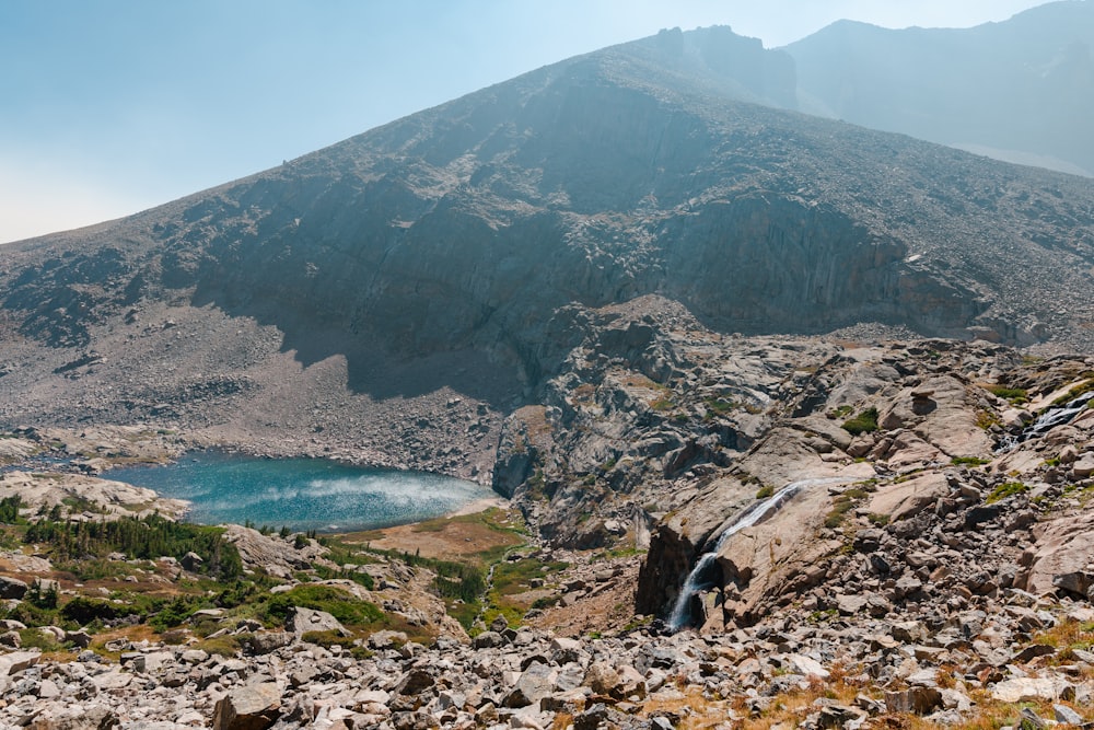 brown rocky mountain beside blue sea under blue sky during daytime