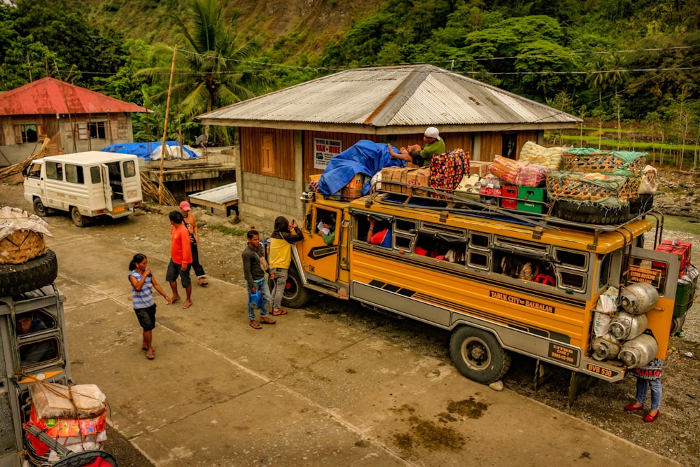 people standing near yellow and blue bus during daytime