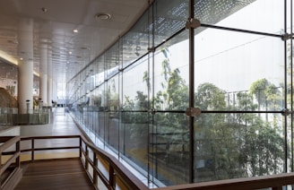 brown wooden bench near glass wall
