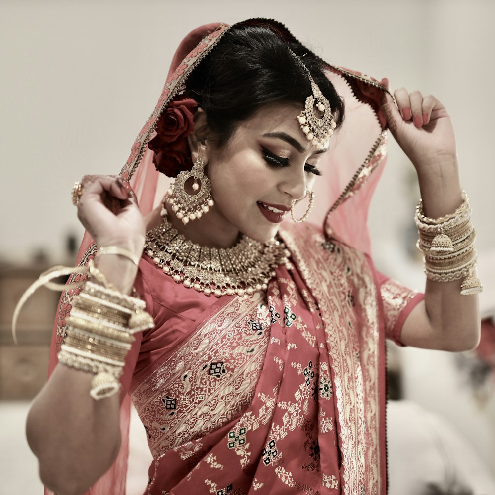 woman in red and gold sari dress holding gold crown