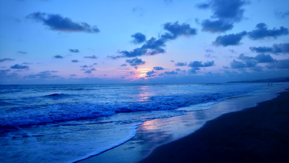 mare blu sotto cielo blu e nuvole bianche durante il giorno