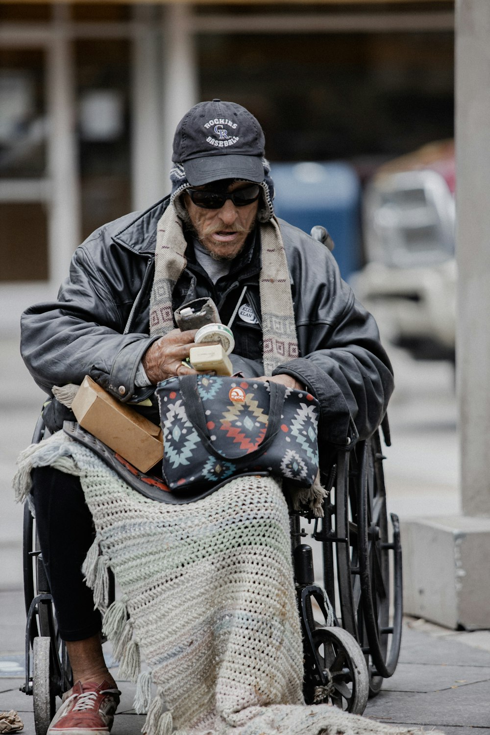 woman in black jacket and blue denim jeans sitting on black wheel chair