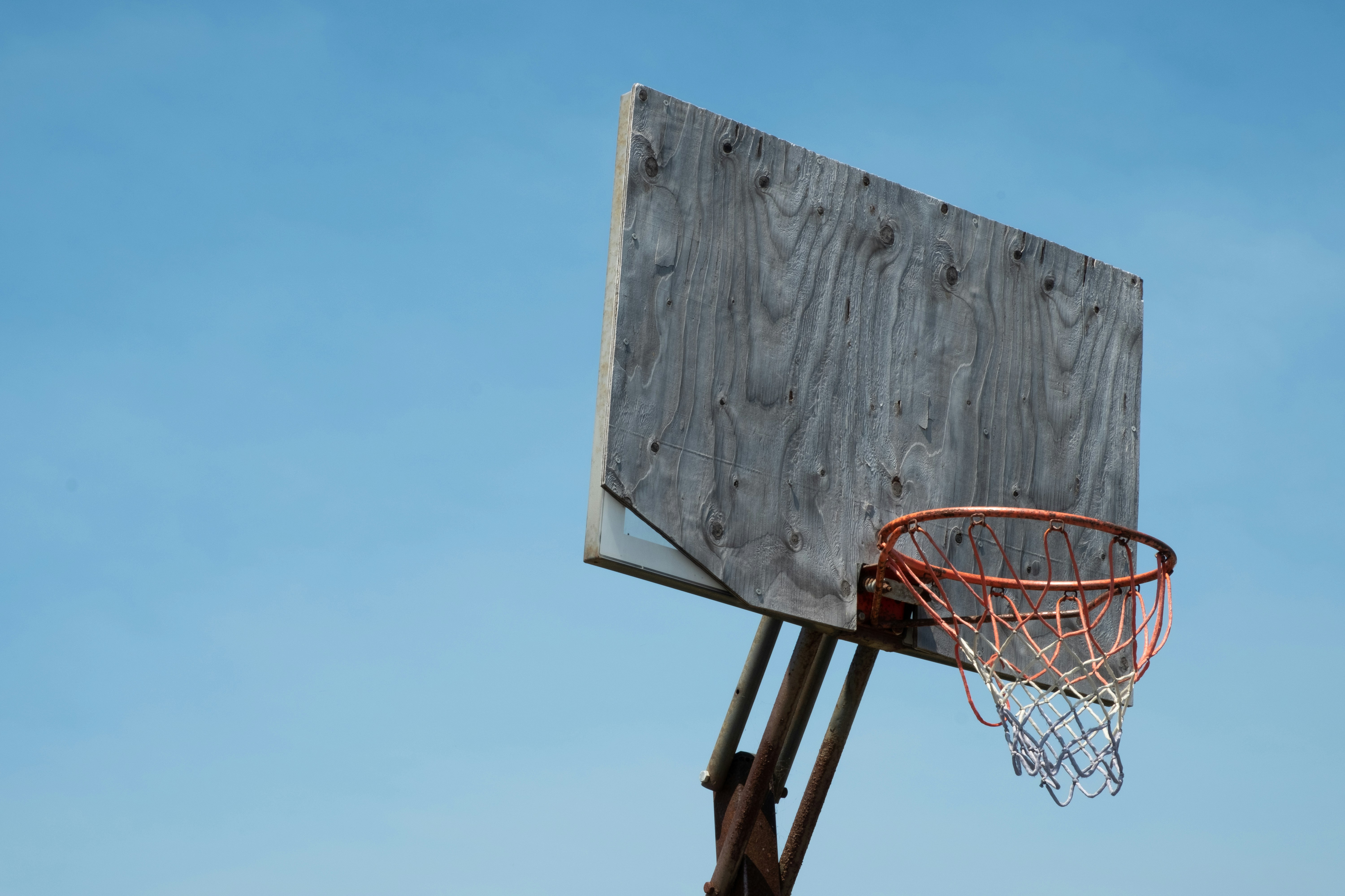 brown and white basketball hoop under blue sky during daytime