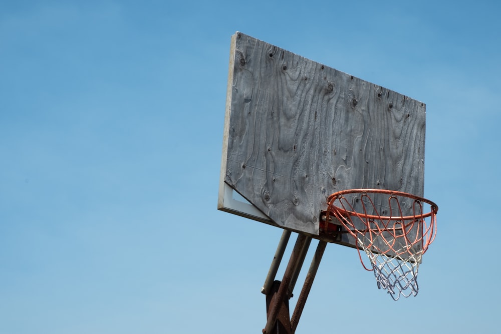 canestro da basket marrone e bianco sotto cielo blu durante il giorno