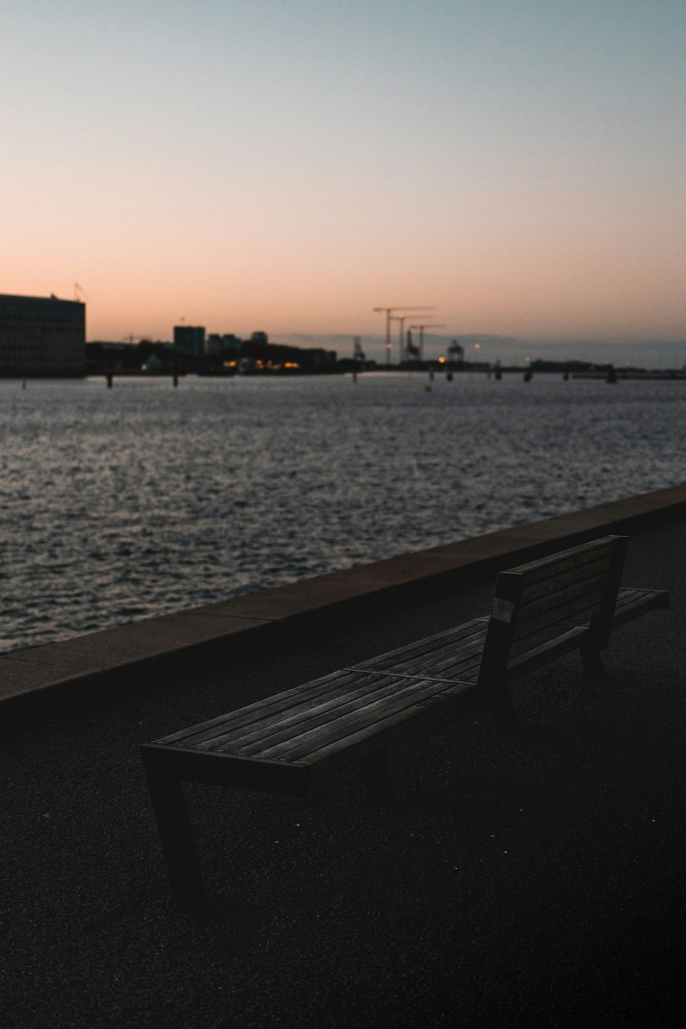 brown wooden bench near body of water during daytime