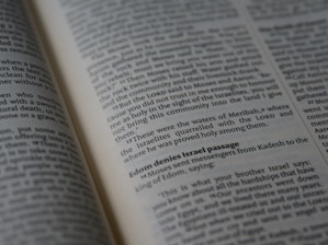 A close-up view of an open book displaying text in English, likely from a religious or historical context. The text appears to be formatted in paragraphs with some sections in bold, possibly indicating headings or significant passages.