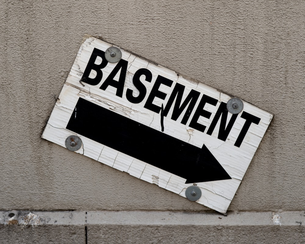 a sign on the side of a building that says basement