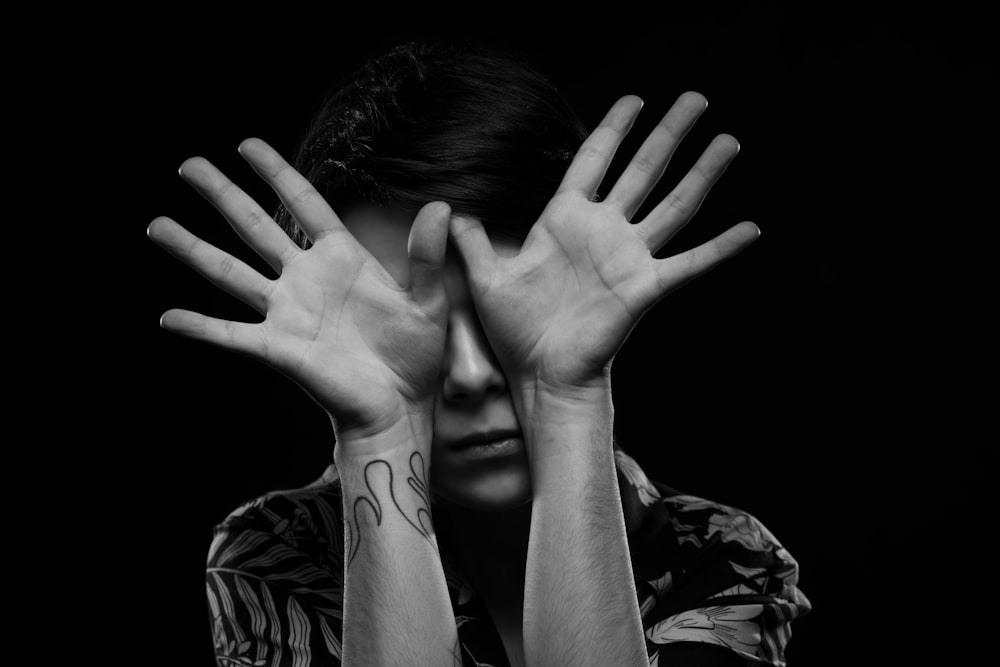 grayscale photo of woman covering face with hands