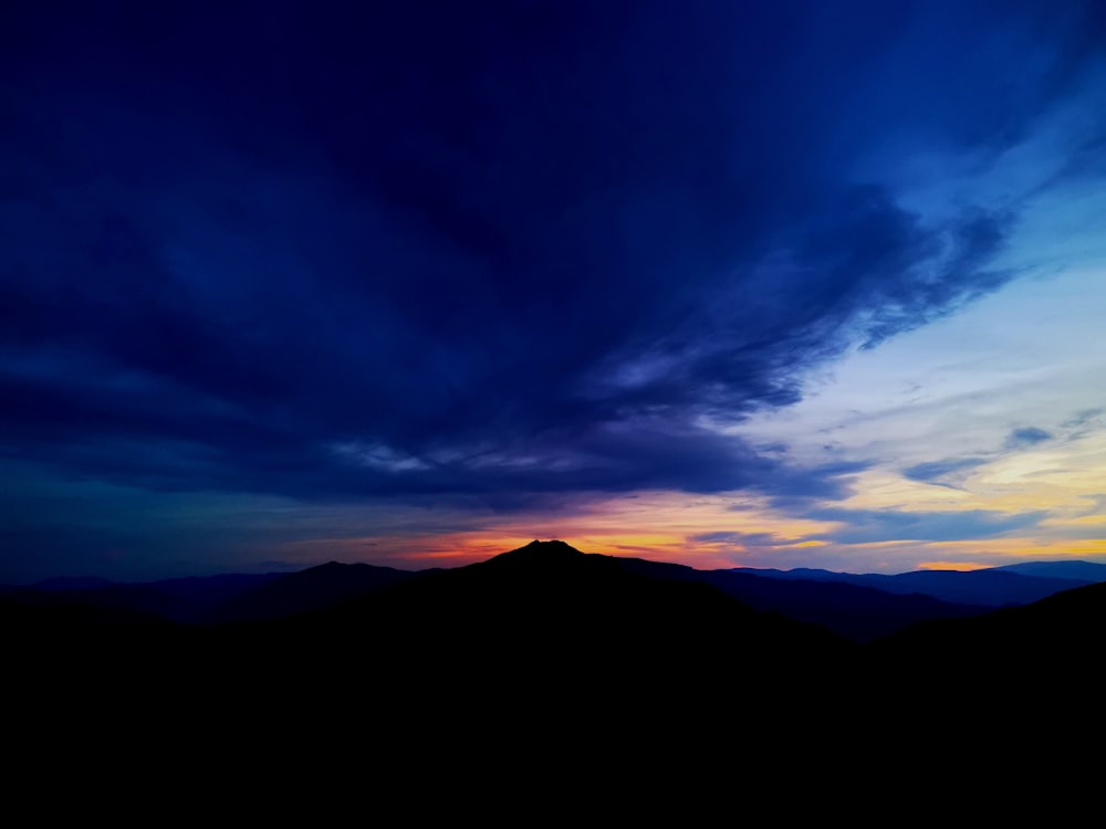 silhouette of mountain under blue sky during sunset