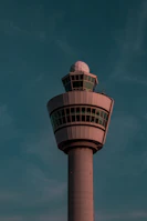 Modern control tower at dusk bathed in soft pink and blue lighting reflecting the brand colors.