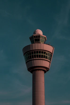 Modern control tower at dusk bathed in soft pink and blue lighting reflecting the brand colors.