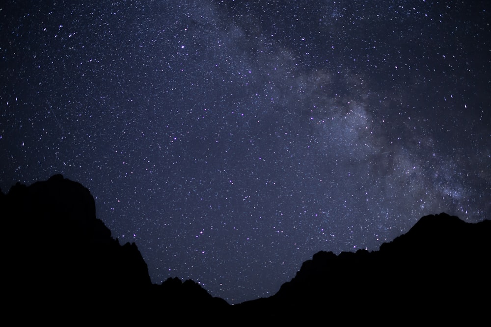 Silueta de montaña bajo la noche estrellada