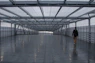 man in black shirt walking on gray concrete floor