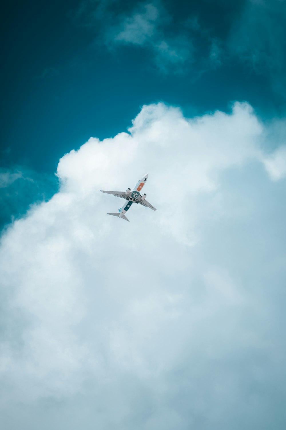 white airplane in mid air under blue sky during daytime