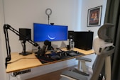 A clean, modern workspace with a microphone and speaker on the desk, highlighting the factory's products.