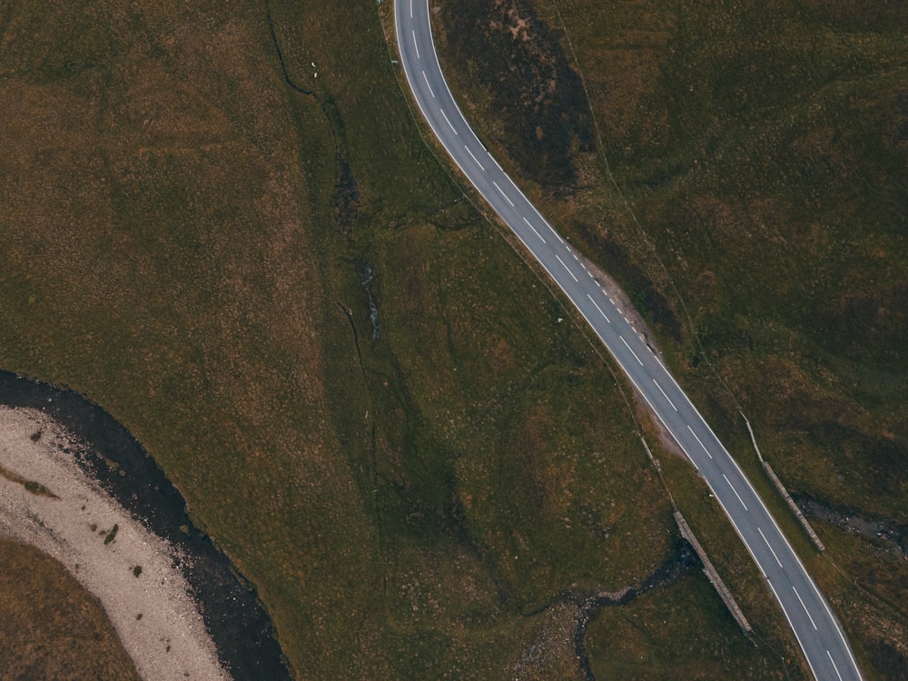 aerial view of road in the middle of green grass field