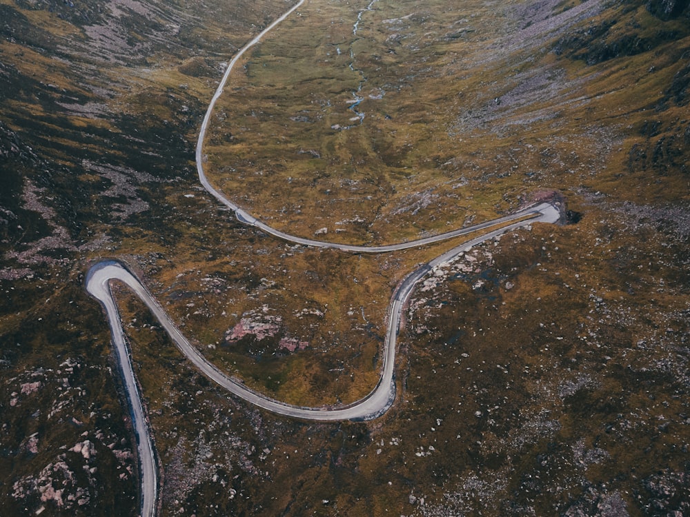 aerial view of road in the middle of green grass field