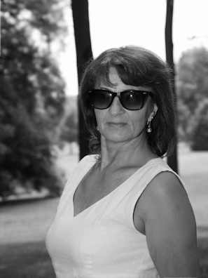 Teacher with short hair and a confident look, standing outdoors.