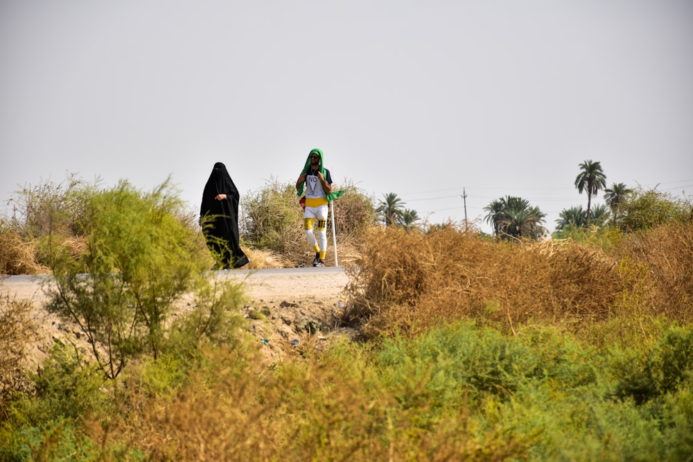 woman in black jacket walking on dirt road during daytime