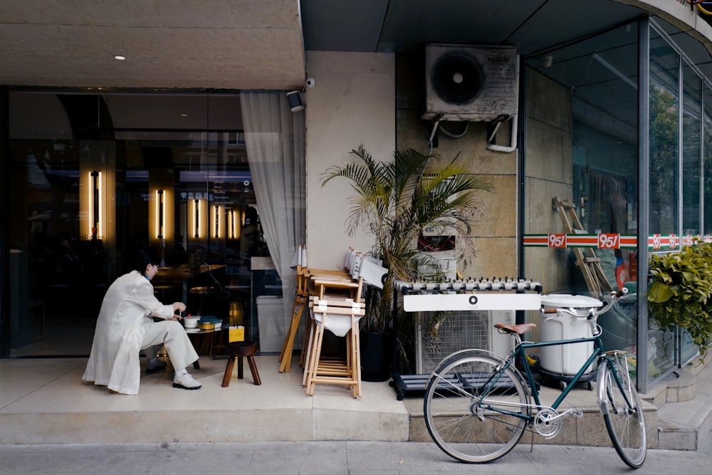 man in white long sleeve shirt standing beside white bicycle