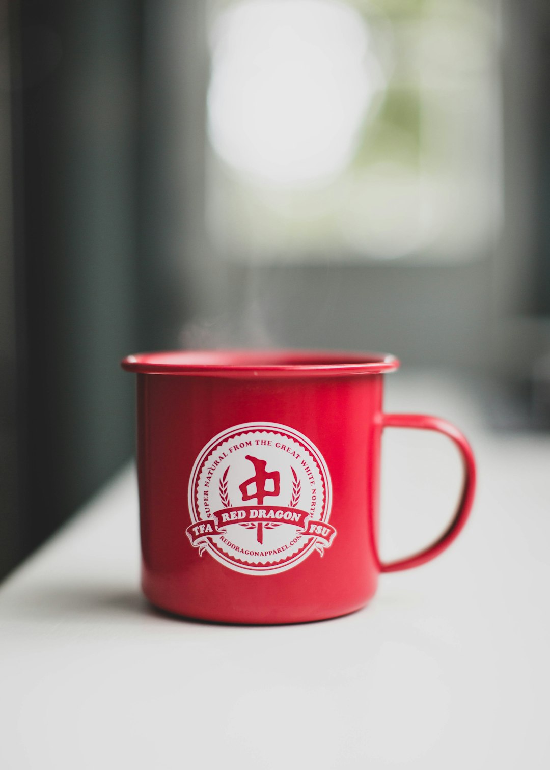 red and white ceramic mug on white table