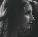 Elegant side profile showing long, voluminous black extensions styled in loose waves.