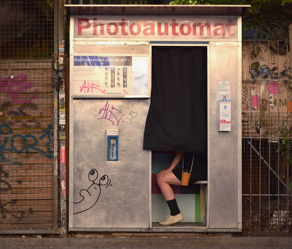 woman in black dress standing on brown brick floor