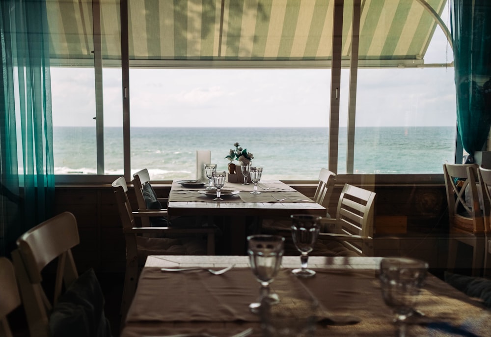 brown wooden table with chairs near window