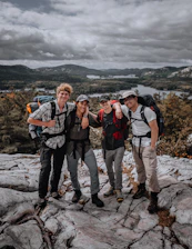 A group of travelers enjoying a scenic local destination with smiles and backpacks.