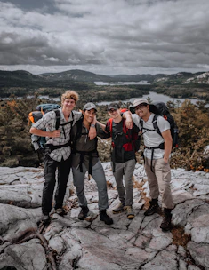 A group of travelers enjoying a scenic local destination with smiles and backpacks.