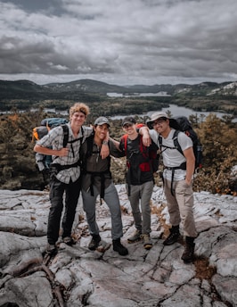 A group of young travelers enjoying a scenic view on a mountain hike.