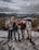 A happy small group of travelers smiling together on a scenic mountain trail.