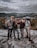 A happy small group of travelers smiling together on a scenic mountain trail.
