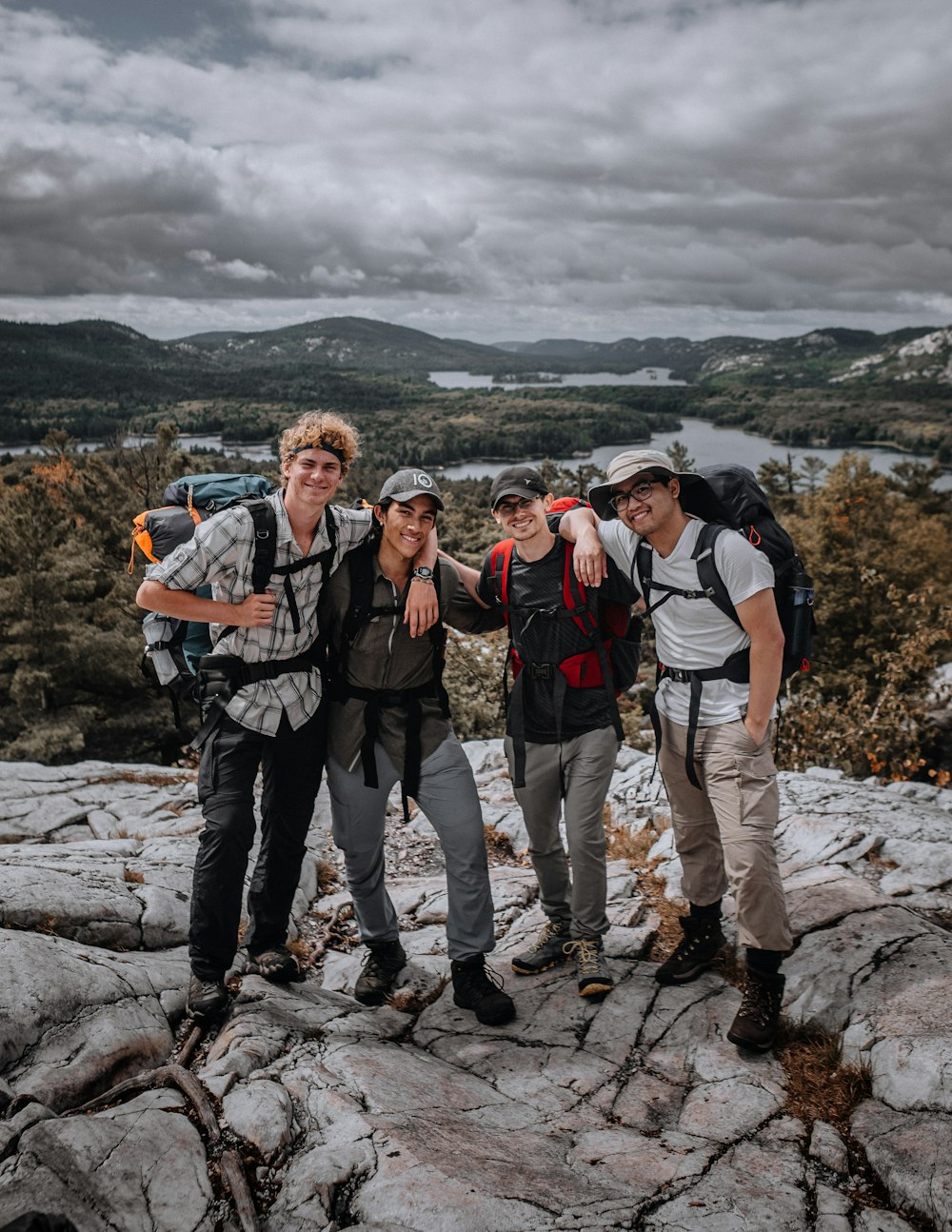 3 men standing on rocky mountain during daytime