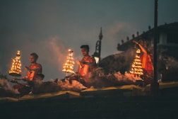 people sitting on brown wooden bench during night time
