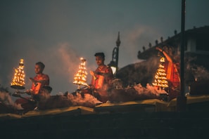 Devotees lighting traditional oil lamps during a temple ceremony at dusk.