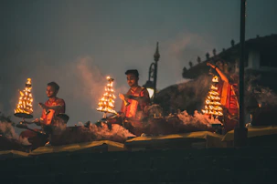 Devotees lighting traditional oil lamps during a temple ceremony at dusk.