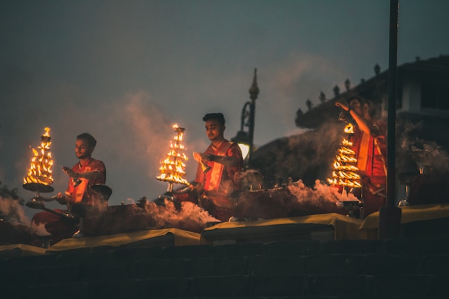 Devotees lighting oil lamps during an evening aarti at Kunda Dham temple