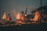 Three individuals are performing a ritual with brass lamps, emitting multiple flames, amidst swirling smoke. They are dressed in traditional attire, adding a sense of ceremony against a twilight backdrop.