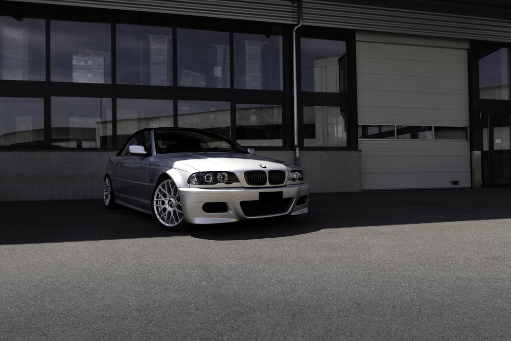 silver bmw m 3 parked in front of white building