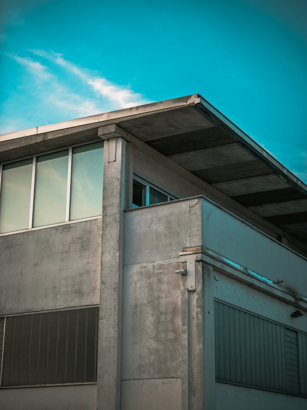 Graues Betongebäude unter blauem Himmel tagsüber