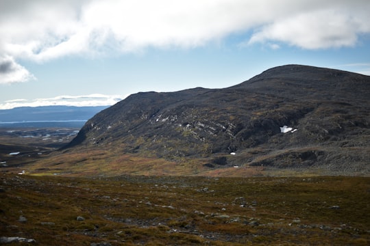 green and brown mountains under white clouds and blue sky during daytime in Jämtland Sweden