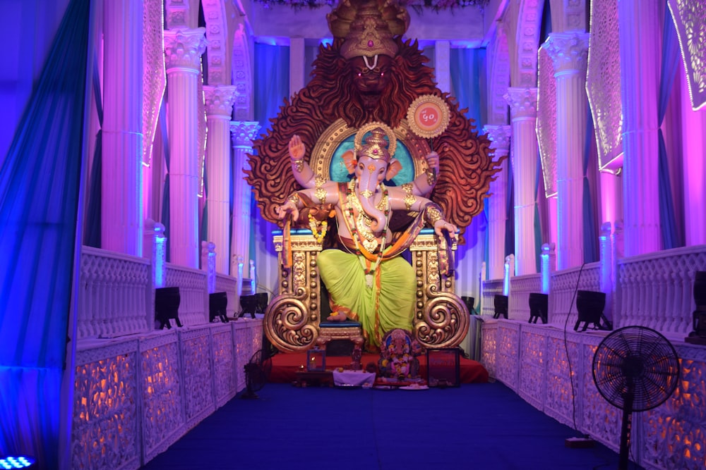 gold hindu deity statue on purple couch