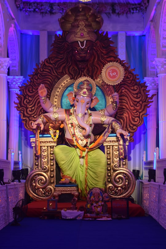 gold hindu deity figurine on brown wooden table in Surat India