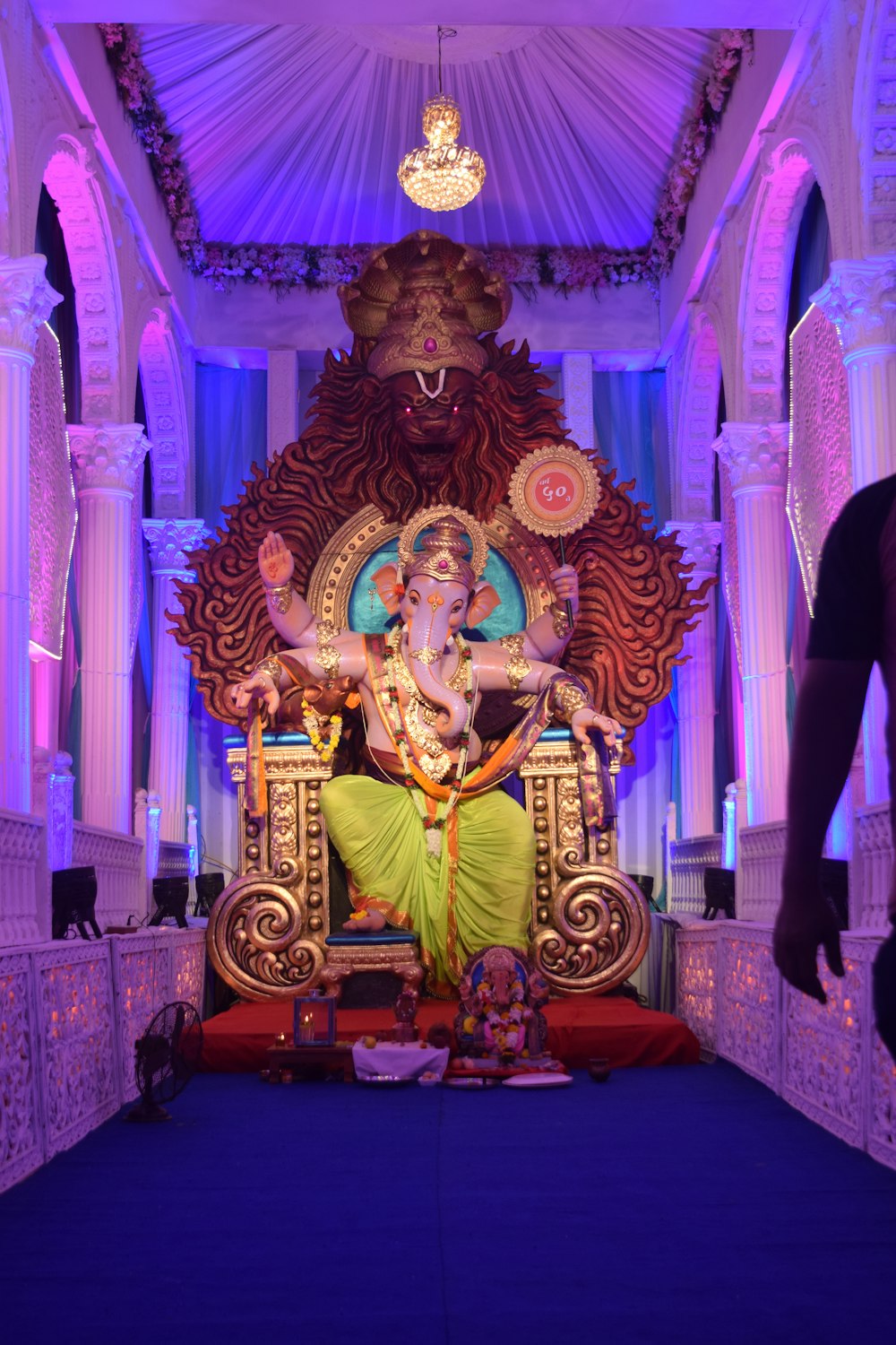 gold hindu deity statue on purple couch