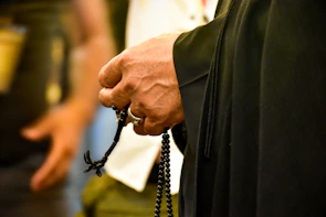 Close-up of hands holding a rosary during a quiet moment of devotion.