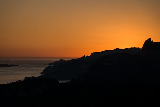 silhouette of mountain near body of water during sunset in Cassis France