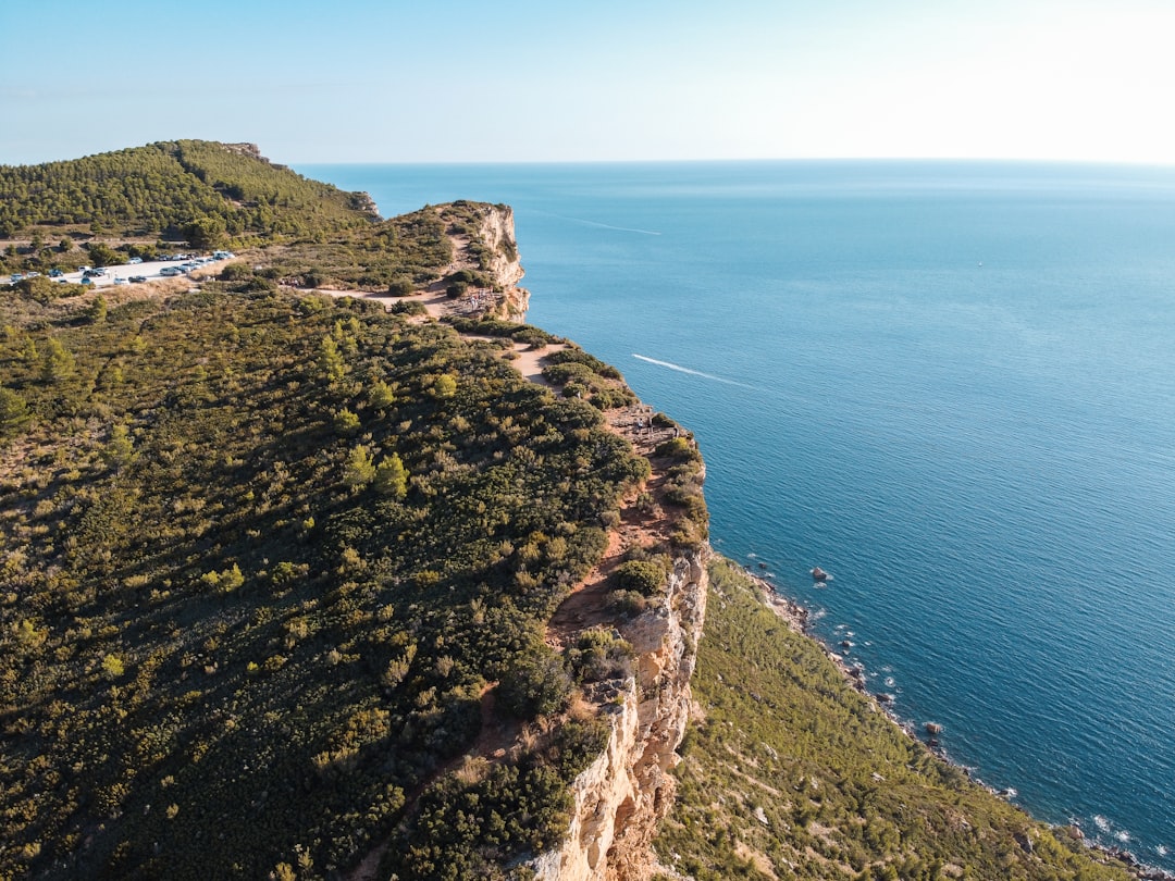 green and brown rock formation beside blue sea under blue sky during daytime